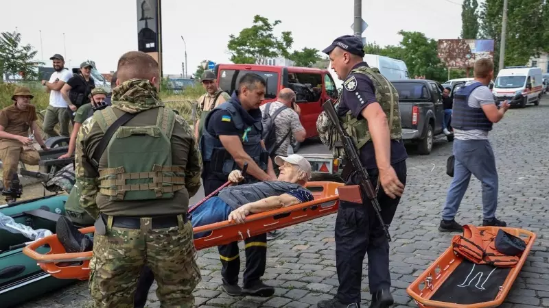 La policía evacua a un residente local de un área inundada después de que se rompiera la represa de Nova Kakhovka, en medio del ataque de Rusia a Ucrania.