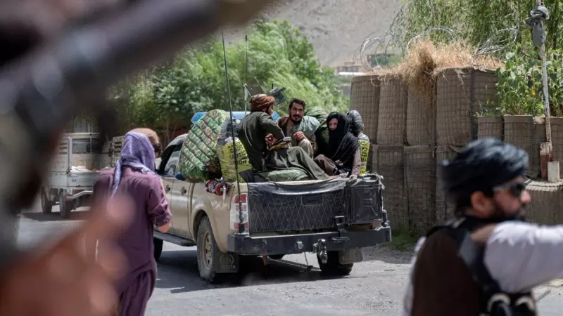 En esta fotografía tomada el 8 de julio de 2022, los combatientes talibanes pasan por un puesto de control de carretera cerca en la provincia de Panjshir, en Afganistán.