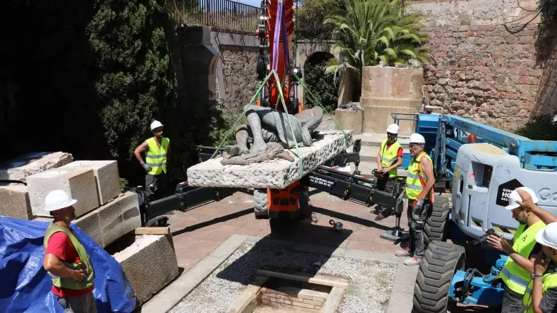 Un grup d'operaris traslladant l'àngel del Monument als caiguts, al Castell de Montjuïc