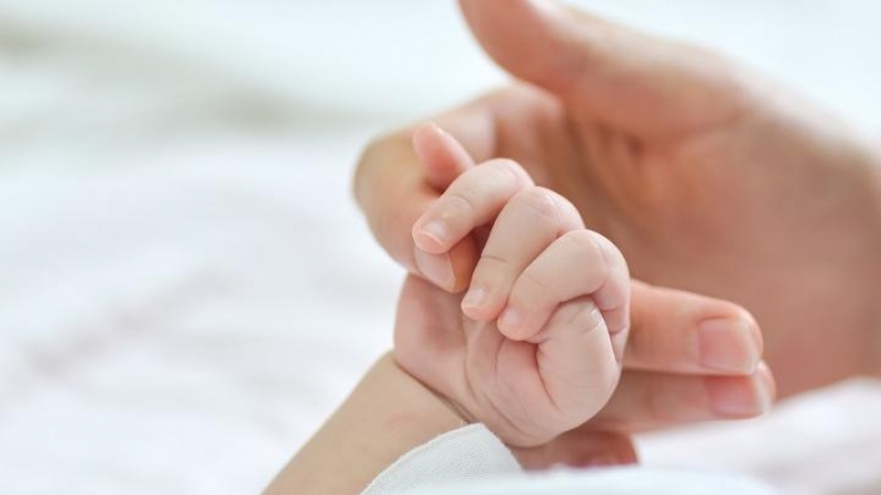 Una mujer da la mano a un bebé (Archivo)