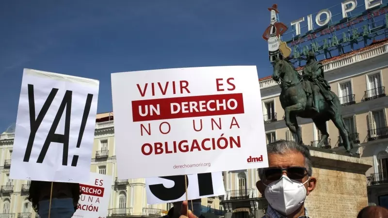 Un grupo de personas se reúne sosteniendo pancartas y carteles durante la concentración de la asociación Derecho a Morir Dignamente en la Puerta del Sol, a 25 de junio de 2021, en Madrid, (España)