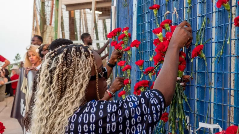 Manifestantes depositan flores en la verja del paso fronterizo de Barrio Chino, epicentro de la tragedia de Melilla del año pasado.