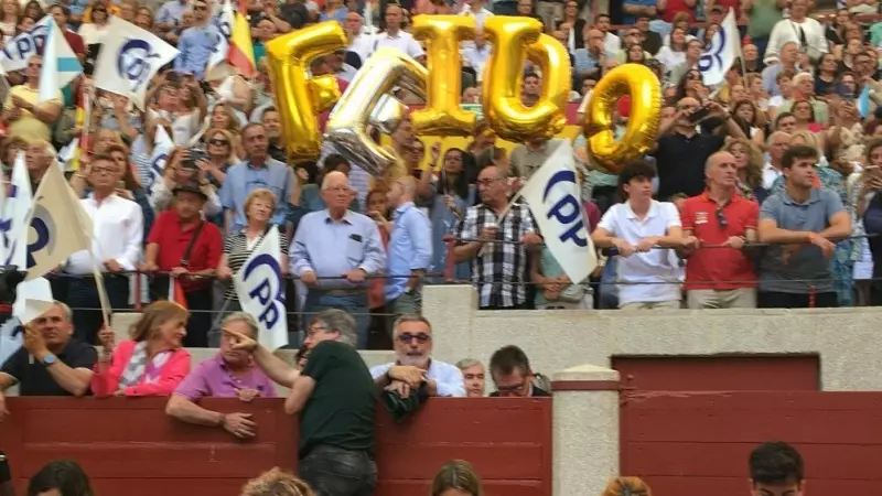 Simpatizantes del PP con globos dorados con las letras del nombre de Feijóo, el domingo en un tendido de la plaza de toros de Pontevedra sobre los escritorios de prensa.