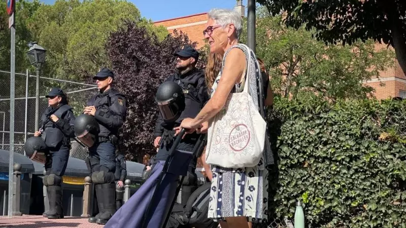 Una vecina de Móstoles se planta con el carro de la compra frente a los antidisturbios que desalojan el Edificio Dignidad, donde viven 18 familias.