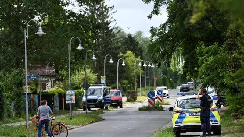 Una mujer con una bicicleta habla con un policía en una zona residencial después de que la policía de Berlín advirtiera al público que una supuesta leona andaba suelta en Stahnsdorf, cerca de Berlín , Alemania, el 20 de julio de 2023.