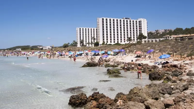 24/07/2023.- Varias personas disfrutan de la playa de frente al hotel Meliá Sol Son Bou en Alayor, Menorca este lunes.