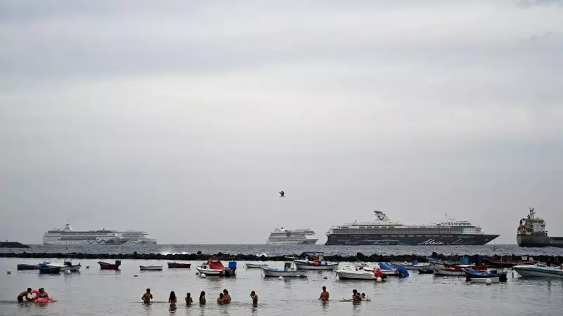 La gente disfruta de un baño mientras los cruceros están anclados en la playa de Los Cristianos, en la costa sur de la isla canaria de Tenerife, España, en el verano de 2021.