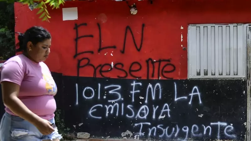 Una mujer pasa frente a una casa con un grafiti de la guerrilla del ELN cerca de Cacuta, Colombia, a 4 de julio.