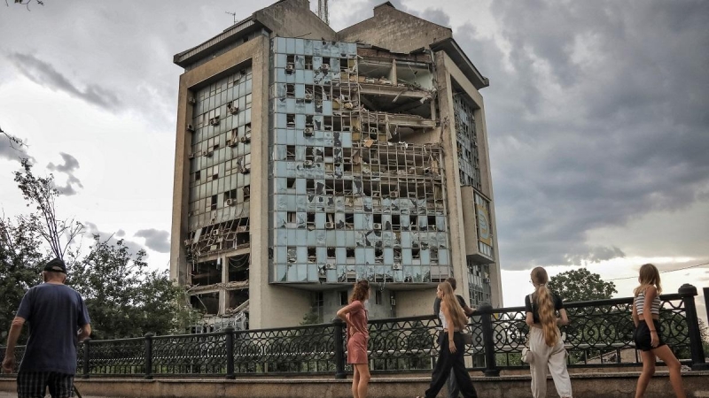 Varias personas pasan frente a un edificio destruido en un ataque ruso con drones en Izmail, en la región ucraniana de Odesa, a 2 de agosto de 2023