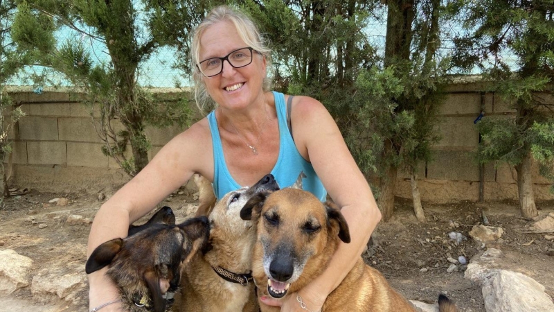 11/08/2023 - Eva M. González, voluntaria en la protectora Regufiados, junto a varios perros del refugio, a 11 de agosto de 2023.