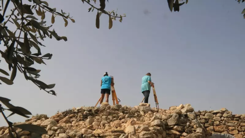Dues membres del Grup de Recerca de la Universitat de Barcelona analitzen topogràficament el jaciment de Sant Jaume d'Alcanar