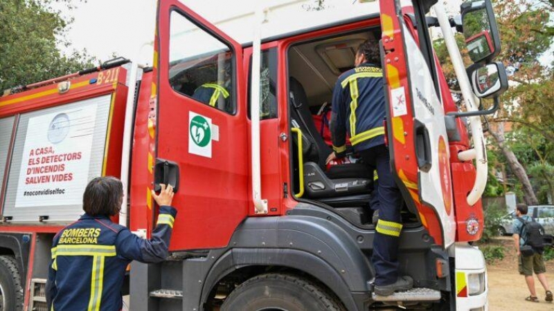 Diversos bomberos suben a uno de los camiones de extinción durante el simulacro del mes de mayo.