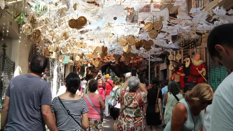 Gent fotografia el guarnit del carrer Verdi durant la Festa Major de Gràcia