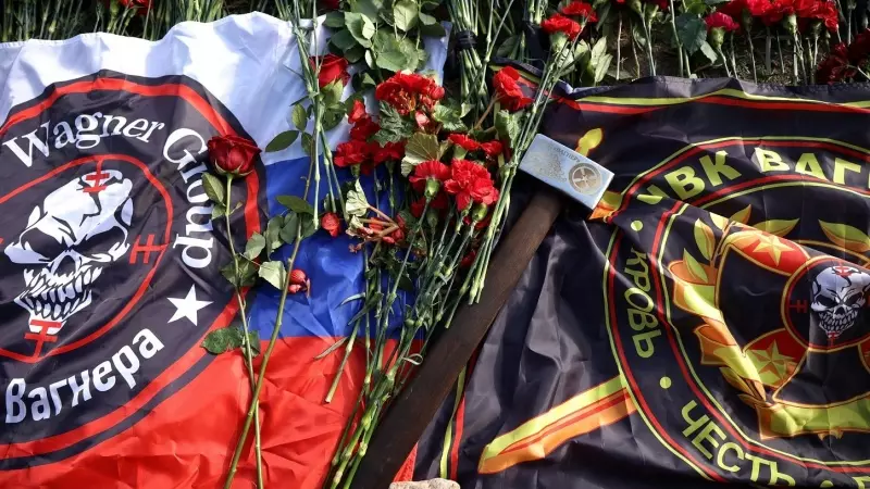 Banderas y un mazo con el logotipo de Wagner entre las flores colocadas en un monumento improvisado cerca de la antigua sede del grupo de mercenarios en la ciudad rusa de San Petersburgo. REUTERS/Anastasia Barashkova