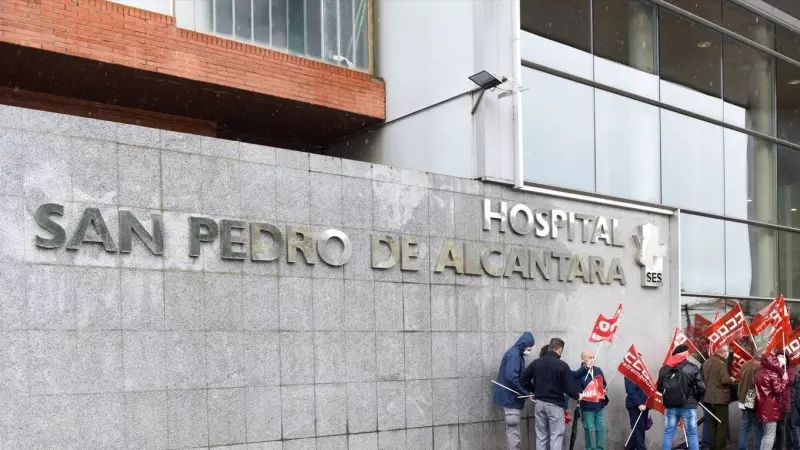 Manifestantes de CCOO y personal sanitario portan banderas de CCOO durante la concentración convocada por los precios de la energía eléctrica frente al Hospital San Pedro de Alcántara, a 23 de marzo de 2022, en Cáceres, Extremadura (España).