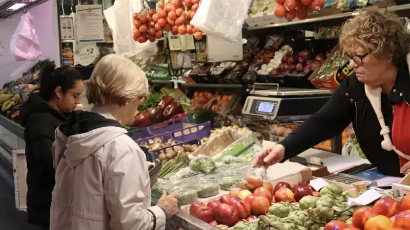 Clients comprant fruita en una parada del Mercat del Lleó de Girona