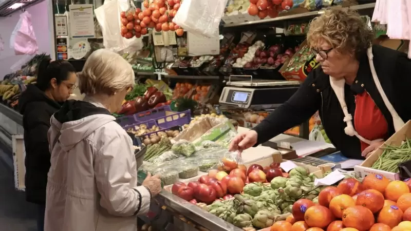Clients comprant fruita en una parada del Mercat del Lleó de Girona