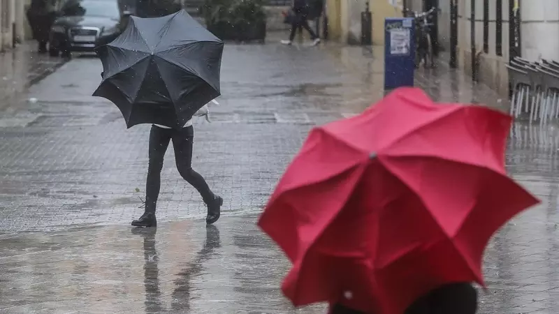 Dos personas sostienen paraguas como consecuencia de la lluvia, a 6 de febrero de 2023, en Valencia, Comunidad Valenciana (España).