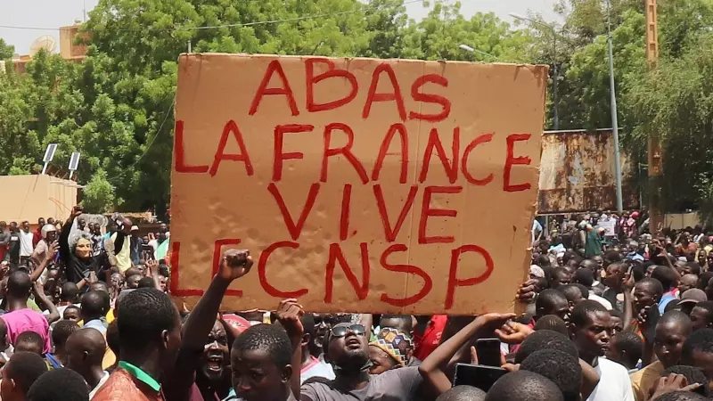 Varios manifestantes sostienen un cartel que dice 'Abajo Francia, larga vida al CNSP' durante una marcha en apoyo de los golpistas en Niamey, a 30/07/2023.