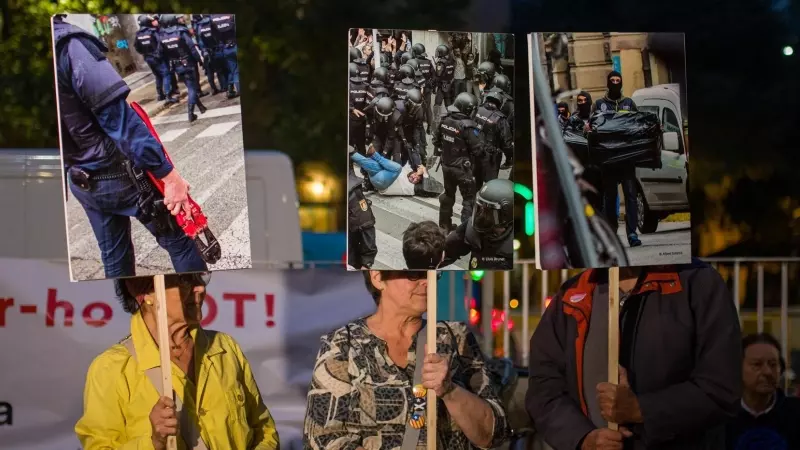 Varias personas con carteles de agentes de policia durante una movilización nocturna en el Institut Balmes, a 30 de septiembre de 2022, en Barcelona