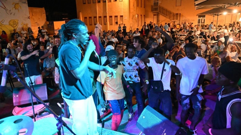 Migrantes recién desembarcados, vecinos y turistas cantan y bailan en una plaza de Lampedusa (Italia), donde han llegado 10.000 migrantes en apenas tres días.
