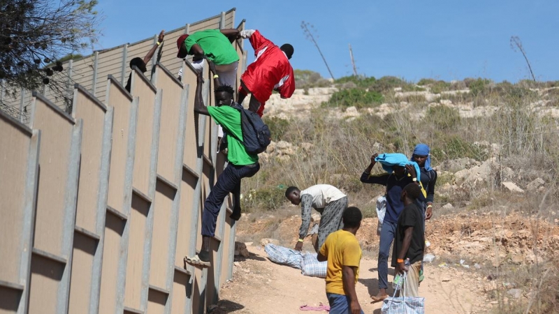 Varias personas migrantes escapan del 'hotspot' de Lampedusa, Italia, colapsado tras la llegada de más de 10.000 personas en tres días.