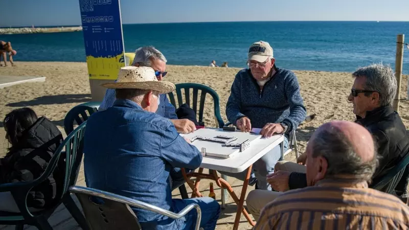 04/0/2023 - Unos hombres juegan al dominó en la playa de la Barceloneta, en Barcelona, Catalunya.