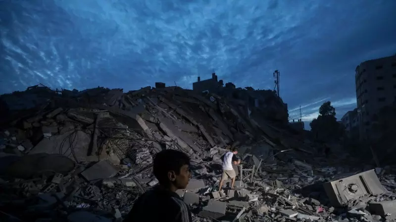 Menores inspeccionan los alrededores destruidos de la Torre Palestina después de que aviones de combate israelíes la atacaran en la ciudad de Gaza, el 7 de octubre de 2023.