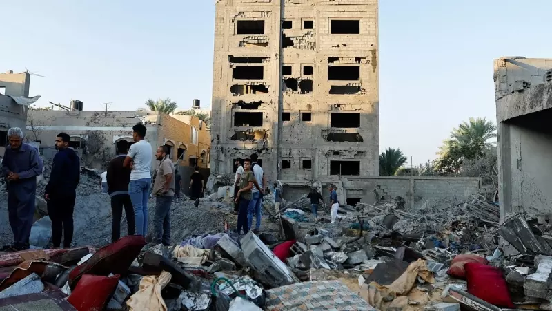 Los palestinos observan la destrucción de una casa tras un ataque de Israel en Khan Younis, en el sur de la Franja de Gaza. REUTERS/Ibraheem Abu Mustafa