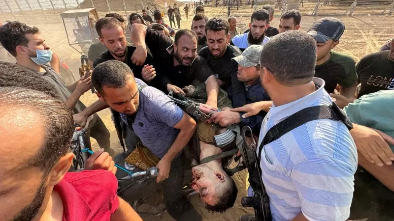 Varios palestinos cargan el cadáver de una persona que, según ellos, es un soldado israelí asesinado por hombres armados de Hamás que se infiltraron en áreas del sur de Israel, en la frontera entre Israel y Gaza, el 7 de octubre de 2023.