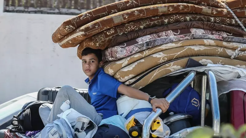 13/10/23 Un menor palestino, subido en la trasera de una furgoneta que escapa de la ciudad de Gaza tras el ultimátum de Israel.