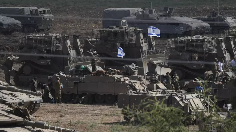Tropas israelíes y vehículos militares, entre ellos tanques, se reúnen en un lugar no revelado a lo largo de la frontera con Gaza.