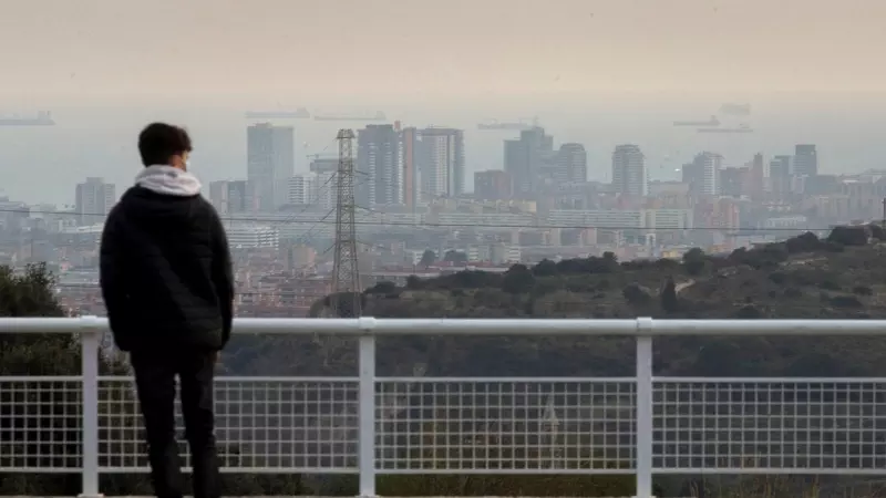 Un ciudadano observa Barcelona durante un episodio de alta contaminación. EFE/ Enric Fontcuberta