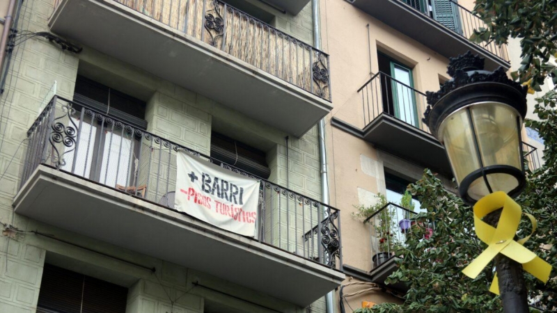 Un cartell amb el lema '+Barri -Pisos Turístics' penjat en un balcó de la Rambla de Girona, en una imatge d'arxiu. Autor: Xavier Pi/ACN