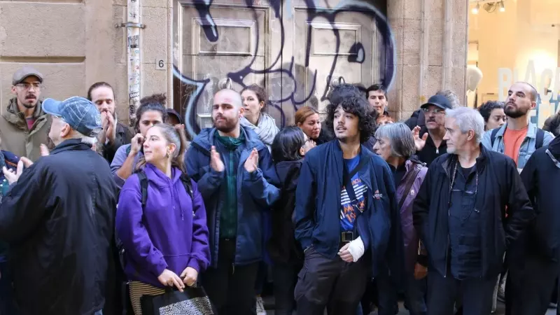 Veïns i activistes davant l'edifici on viu la dona de 78 anys que volen desnonar, al Gòtic de Barcelona.