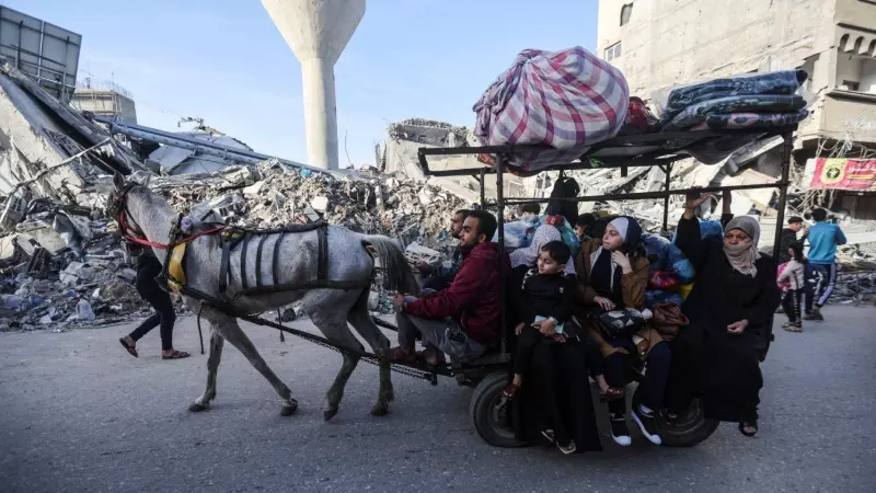Una familia de palestinos desplazados avanzan con su burro aprovechando la tregua entre Israel y Hamás en la destruida ciudad de Khan Younis (Gaza) este 24 de noviembre de 2023.