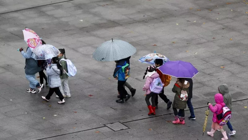 Varios niños se dirigen al colegio con botas y paraguas debido a la lluvia, en Bilbao, a 21/11/2023