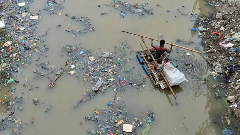 buscando productos de plástico reciclado en el canal lleno de desechos plásticos