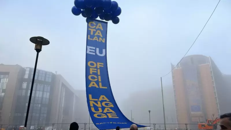 Imatge d'una de les pancartes desplegades per Plataforma per la Llengua davant la seu del Consell de la UE a Brussel·les per reclamar l'oficialitat del català