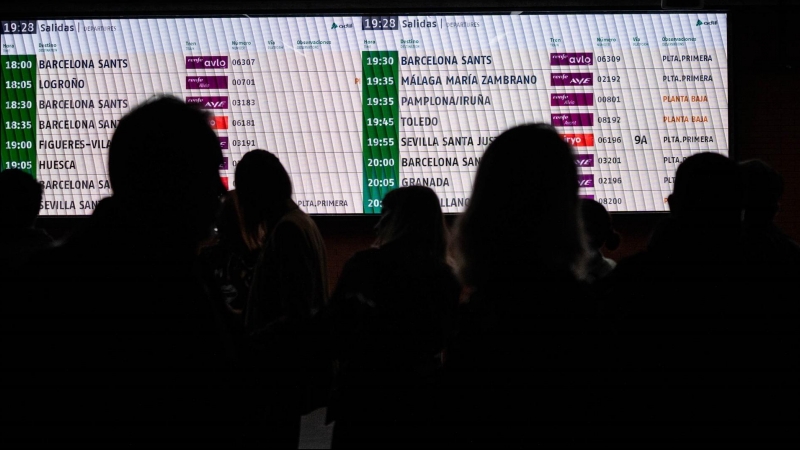 Imagen de archivo de varias personas observando la pantalla de horarios de los trenes en una estación de Madrid.