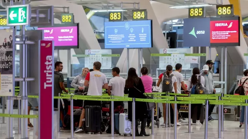 Varias personas en el control de equipaje del aeropuerto Madrid-Barajas, a 5 de diciembre de 2023.