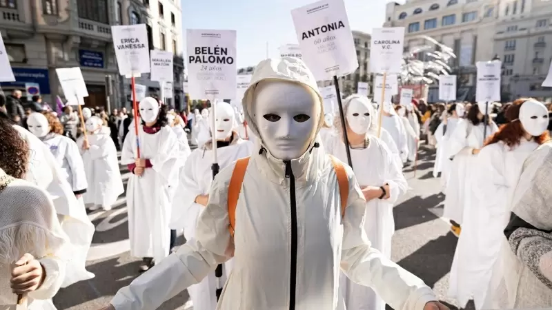 Decenas de personas llevan carteles con nombres de mujeres asesinadas por violencia machista durante una manifestación por el 25N en Madrid.