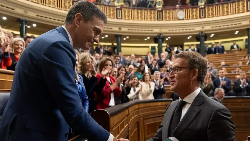 El presidente del Gobierno, Pedro Sánchez (i), saluda al presidente del PP, Alberto Núñez Feijóo (d), tras ser Sánchez votado de nuevo jefe del Ejecutivo en el debate de su investidura