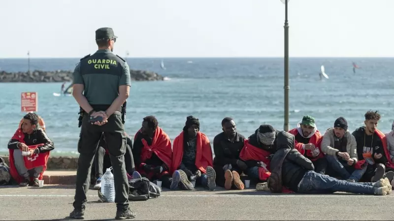 Un agente de la Guardia Civil custodia a un grupo de personas migrantes llegadas en patera a la costa de Teguise, en Lanzarote, a 26 de diciembre de 2023.