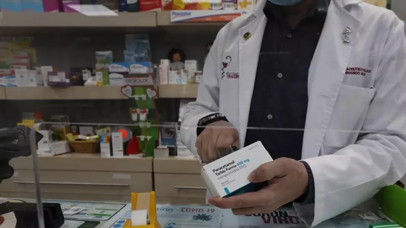 Un farmacéutico recorta el código de barras de una caja de Paracetamol en su farmacia, en Madrid a 20 de abril de 2020