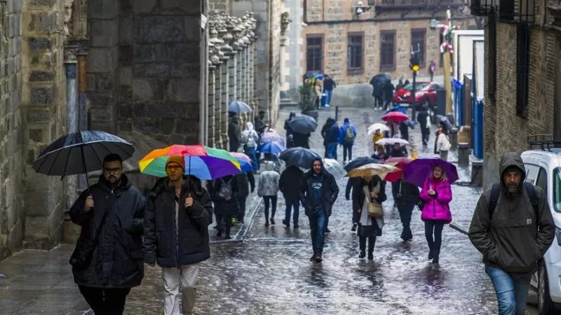 Varias personas caminan bajo la lluvia en Toledo, a 3 de enero de 2024.