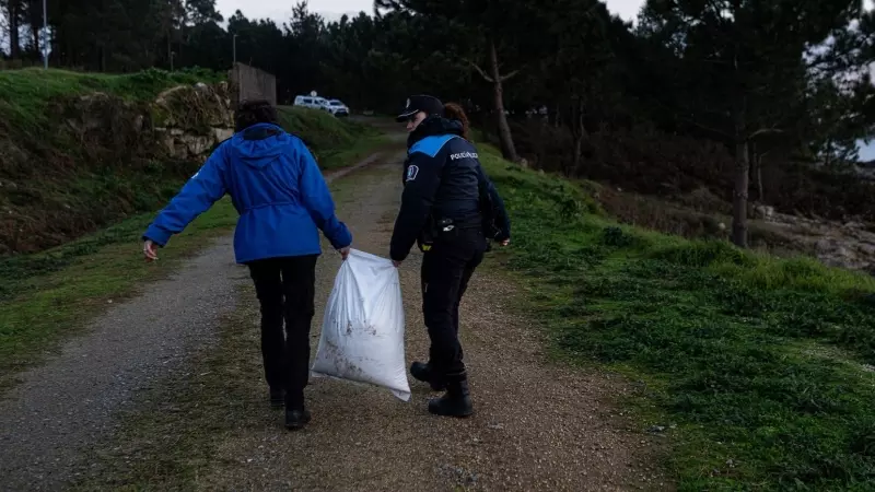 8/1/24 Un policía local de A Illa de Arousa transporta un saco de pellets del ‘Tocano’ el pasado jueves en A Illa de Arousa (Pontevedra).