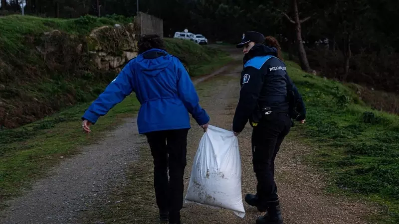 Un agente de la Policía Local y una guarda costas hacen una recogida de pellets de la arena, en la Illa de Arousa, a 4 de enero de 2024.
