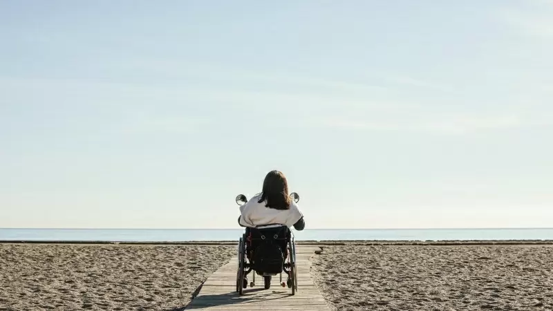 Una mujer en silla de ruedas en la playa (Archivo). — Freepik