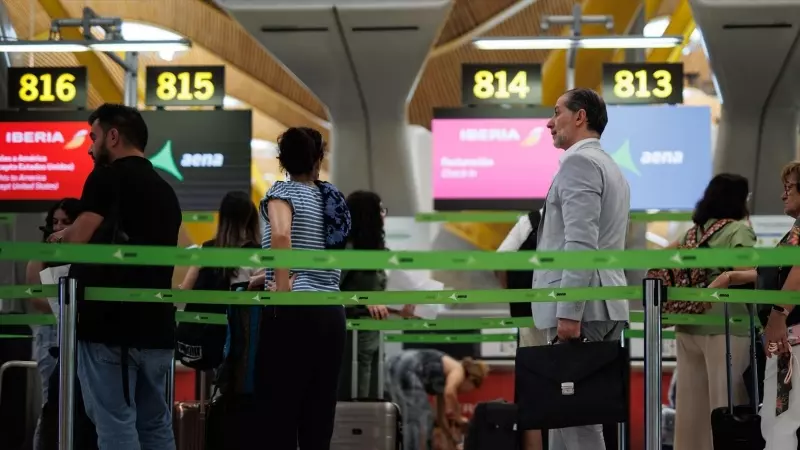 Varios pasajeros en una fila de Iberia en la Terminal T4 del Aeropuerto Adolfo Suárez-Madrid Barajas, a 21 de junio de 2023, en Madrid.